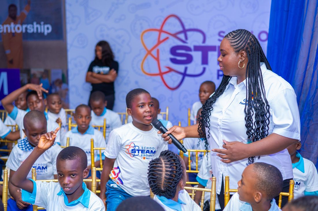 A mentor holding a microphone for a pupil answering a question during a session