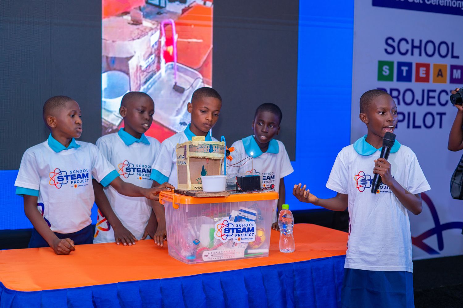 Primary school pupils presenting a water dispenser they built, at the School STEAM Project close-out ceremony