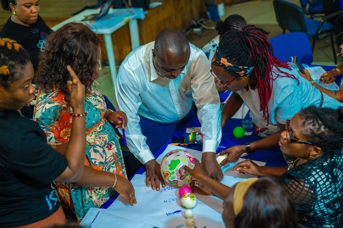 Teachers building a model of the solar system from balls and paper during training